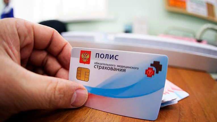 Человек держит полис ОМС